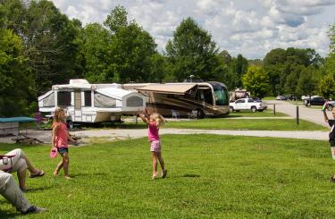 Family playing in open campsite setting