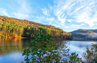 Blue sky over fall landscape and fog rising over Dewy Lake